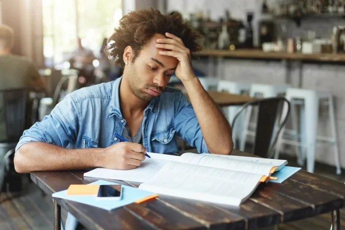 tired-afro-american-college-student-with-curly-hairstyle-blowing-out-his-cheeks-looking-bored-fed-up-losing-patience-while-failing-solve-complicated-mathematical-problem-doing-home-assignment